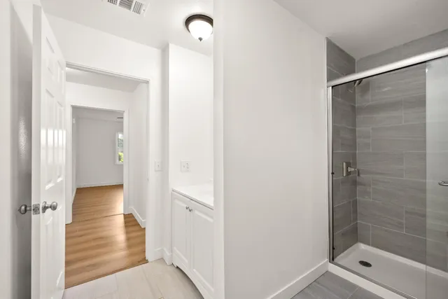 a view of a hallway with wooden floor and closet area