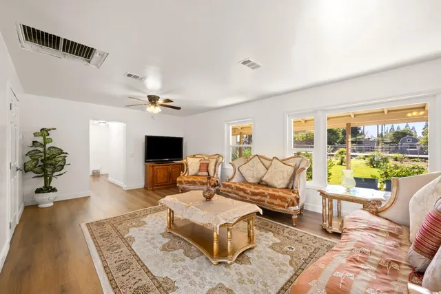 a living room with furniture large window and a flat screen tv