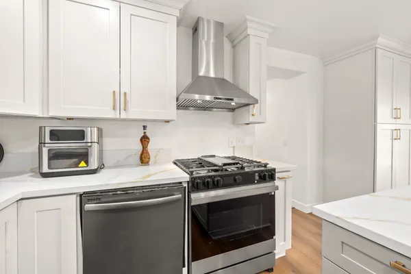 a kitchen with stainless steel appliances granite countertop a stove a microwave and a white cabinets