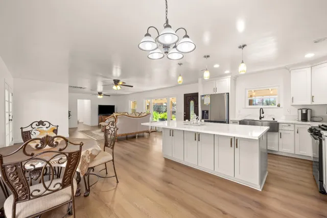 a large white kitchen with lots of counter space dining table and chairs