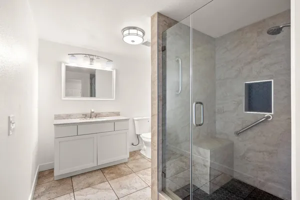 a bathroom with a shower sink and mirror