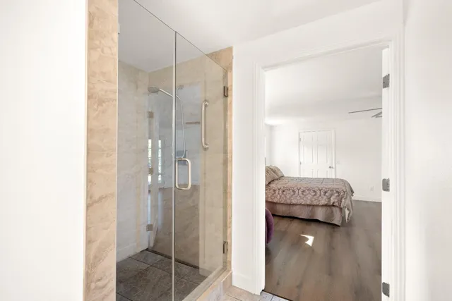 a en suite bathroom with a granite countertop sink and a mirror