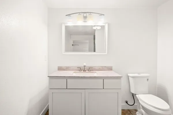 a bathroom with a toilet a sink and mirror