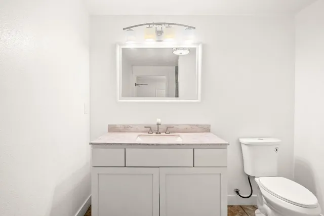 a bathroom with a toilet a sink and mirror