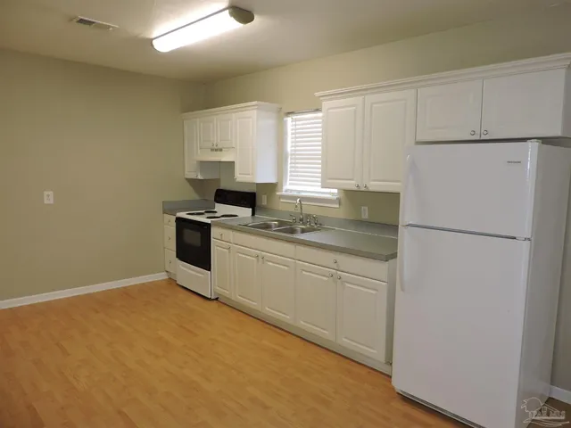 a kitchen with a refrigerator sink stove and cabinets