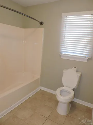 a white toilet sitting next to a bath tub