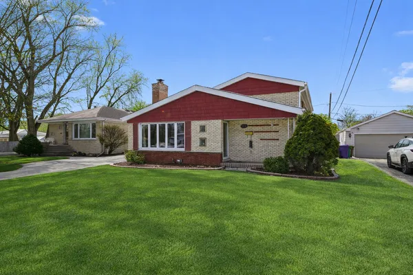 a front view of a house with a garden