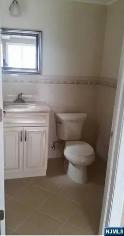 a bathroom with a toilet a sink a vanity and mirror
