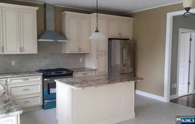 a kitchen with stainless steel appliances granite countertop a stove and a refrigerator