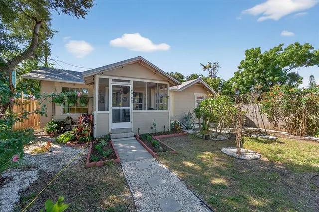 a front view of a house with a yard and potted plants