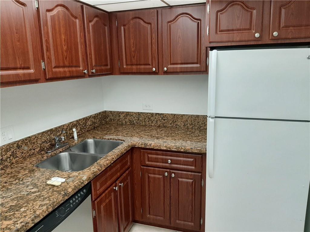 3650 Inverrary Drive, Unit 3Q Lauderhill, FL 33319 - Photo 2 of 16 a kitchen with granite countertop wood cabinets stainless steel appliances and a sink