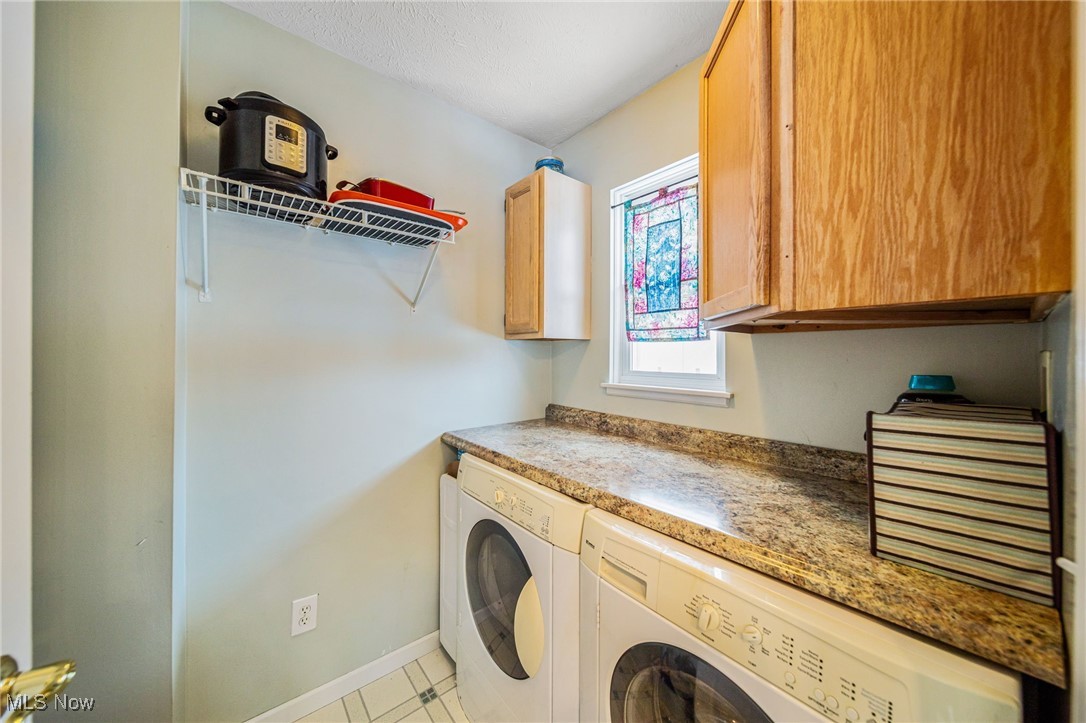 5955 South Ridge Road Madison, OH 44057 - Photo 16 of 42 Clothes washing area featuring cabinets, light tile patterned floors, and washer and clothes dryer