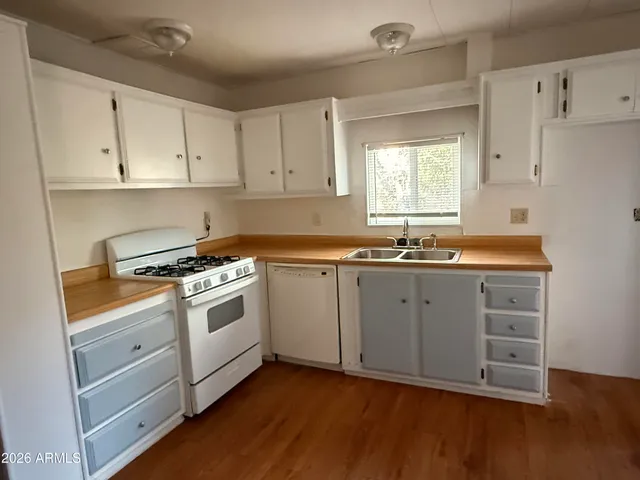 a kitchen with granite countertop white cabinets and white appliances