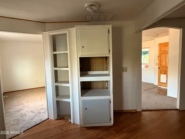a view of an empty room and wooden floor and a cabinet