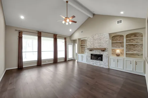 wooden floor fireplace and windows in an empty room