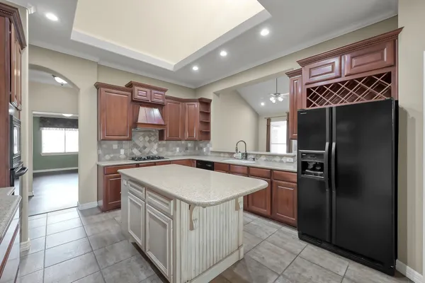 a kitchen with stainless steel appliances granite countertop a sink and a refrigerator