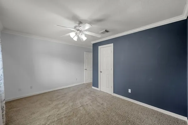 an empty room with a window and a fan