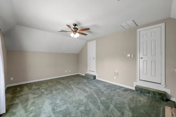 an empty room with closet and a ceiling fan