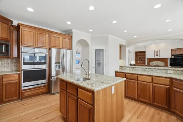 a kitchen with stainless steel appliances granite countertop wooden cabinets sink and stove