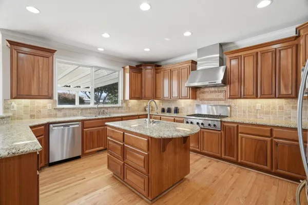 a kitchen with stainless steel appliances granite countertop a sink and a stove