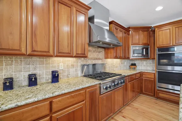 a kitchen with stainless steel appliances granite countertop a refrigerator and microwave