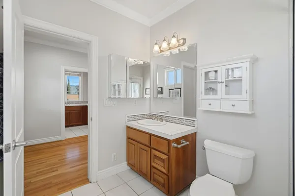 a bathroom with a granite countertop sink a toilet a mirror and shower