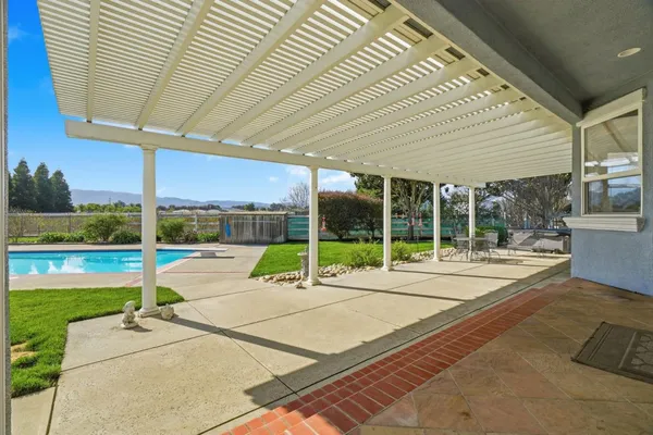 a view of a patio with a table chairs and a backyard