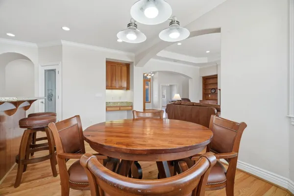 a kitchen with stainless steel appliances granite countertop wooden floor dining table and chairs