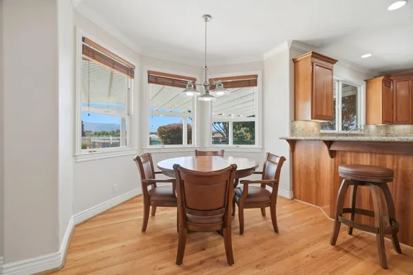a kitchen with stainless steel appliances granite countertop wooden floor and chairs