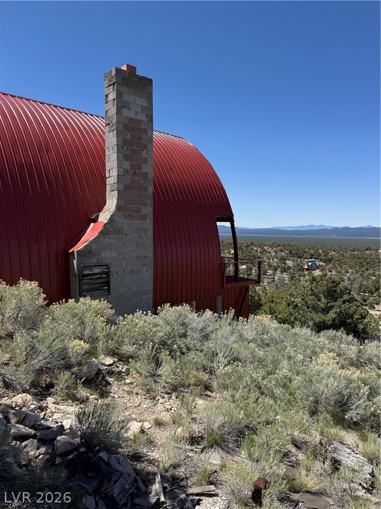 20996 Pinion Pine Road Pioche, NV 89043 - Photo 15 of 19 This unique dwelling features a striking curved red roof, harmonizing with the surrounding natural landscape.