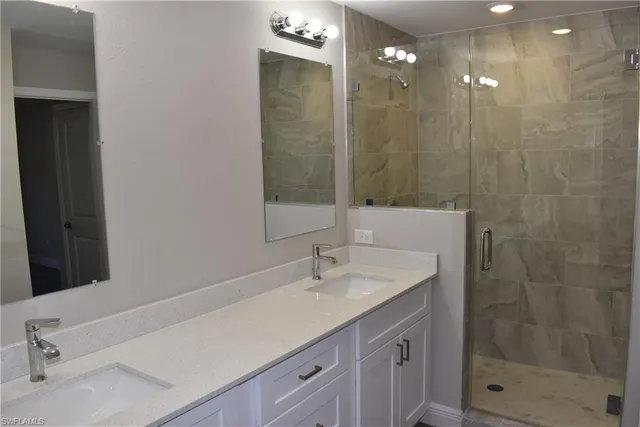 a bathroom with a shower sink and mirror