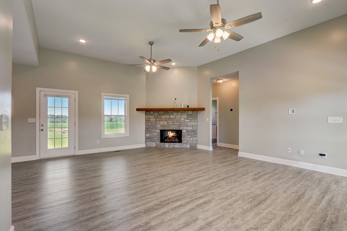 1179 Payne Road Portland, TN 37148 - Photo 6 of 34 an empty room with wooden floor fireplace fan and windows