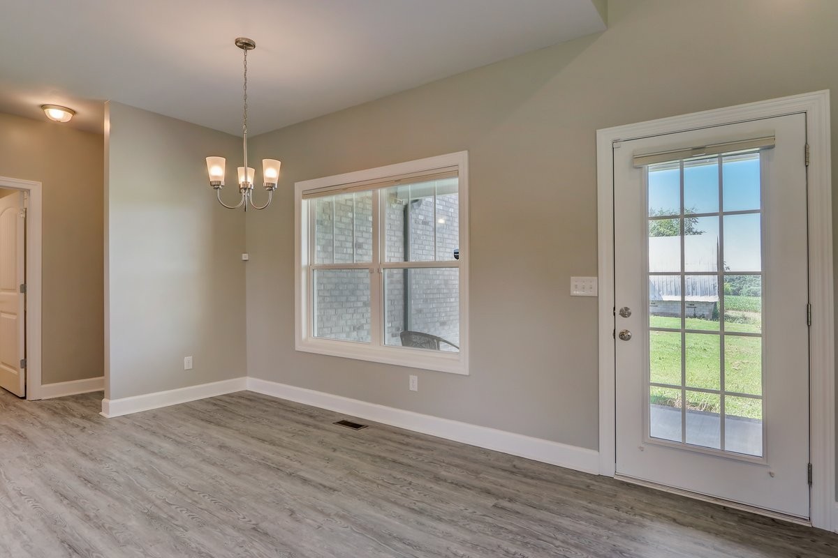 1179 Payne Road Portland, TN 37148 - Photo 7 of 34 an empty room with wooden floor chandelier and windows