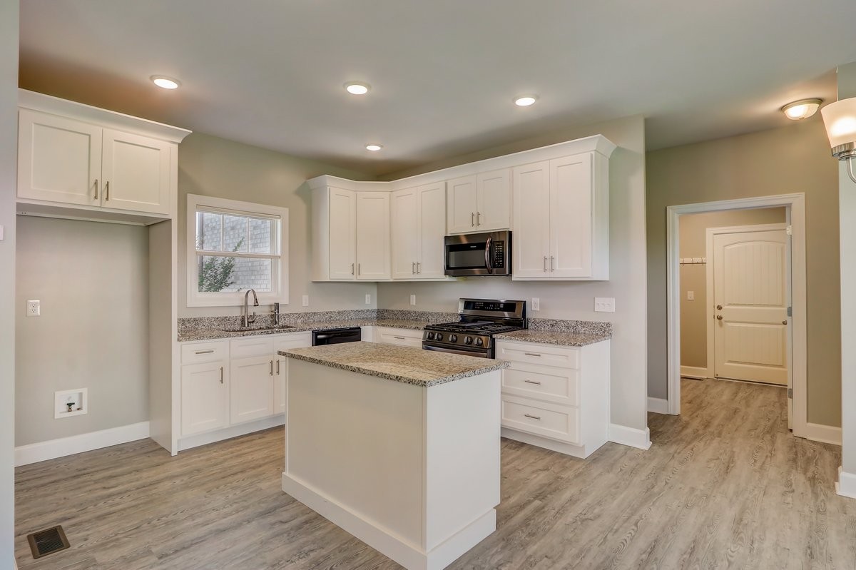 1179 Payne Road Portland, TN 37148 - Photo 8 of 34 a kitchen with cabinets stainless steel appliances a sink and wooden floor