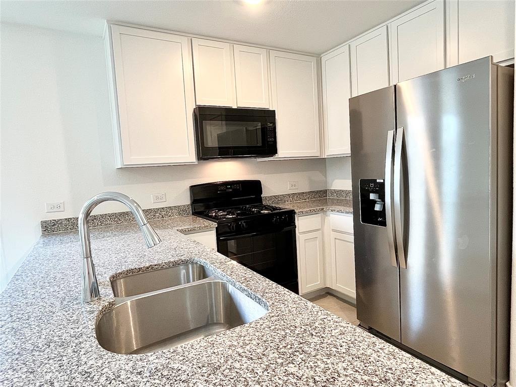 7212 Gray Wolf Lane McKinney, TX 75071 - Photo 1 of 1 a kitchen with stainless steel appliances granite countertop a refrigerator a sink a stove a microwave and cabinets