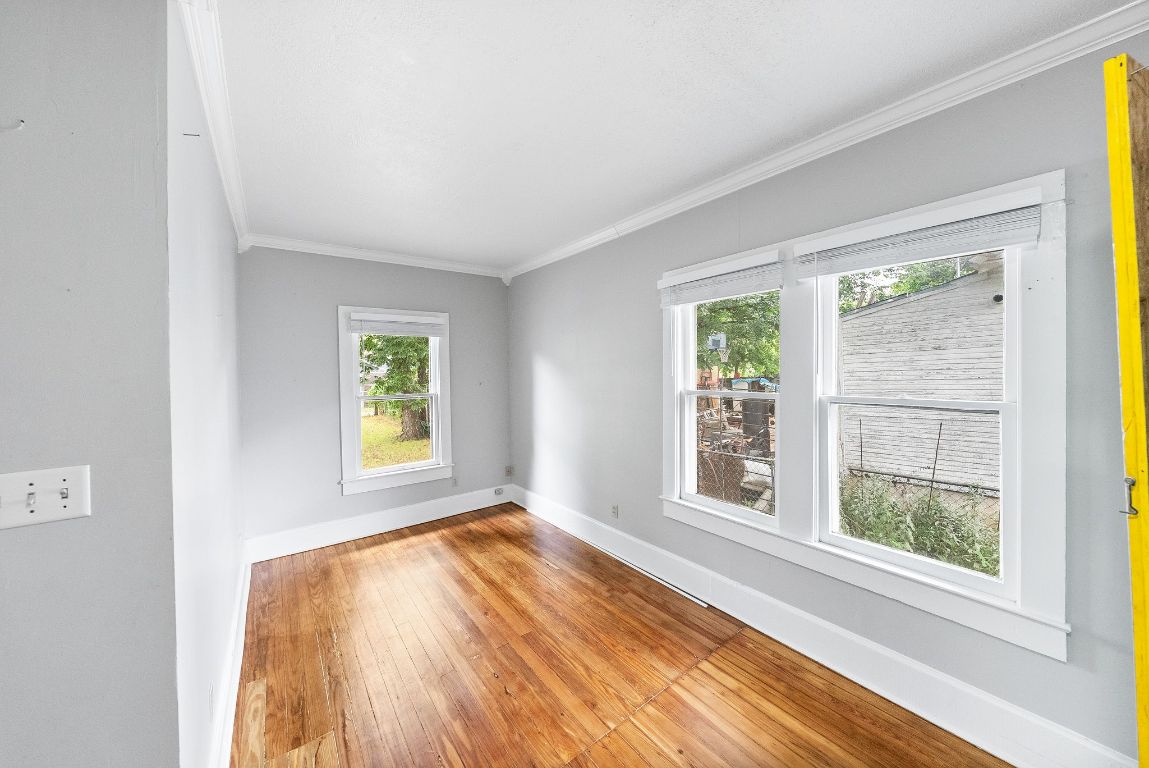 2032 East Cesar Chavez Street Austin, TX 78702 - Photo 12 of 25 Spare room featuring ornamental molding, baseboards, and hardwood / wood-style floors