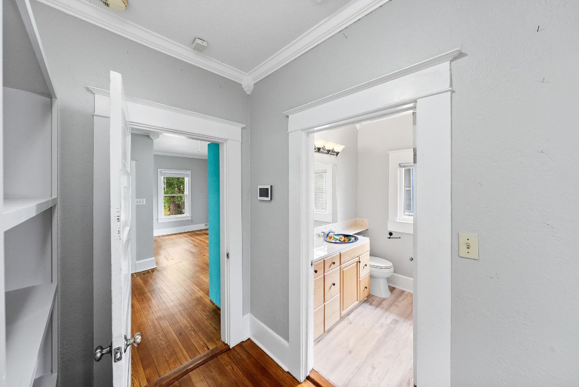 2032 East Cesar Chavez Street Austin, TX 78702 - Photo 14 of 25 Hallway with crown molding, light wood-style flooring, and baseboards