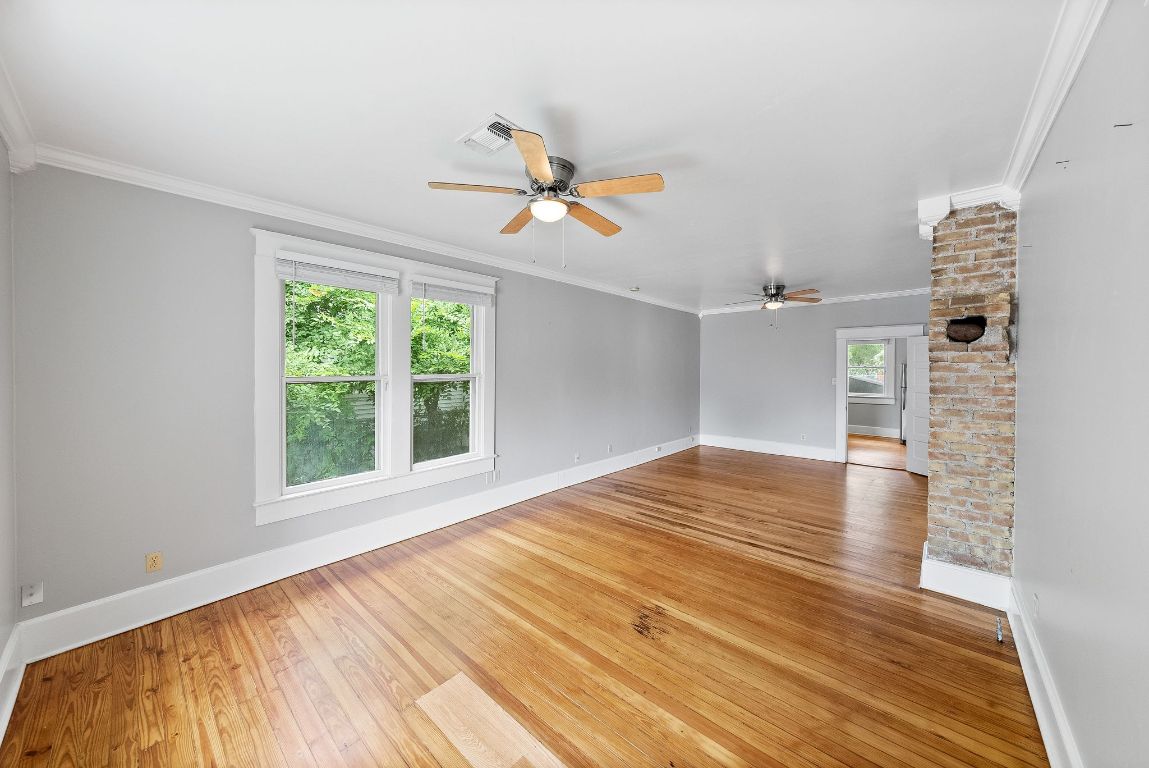 2032 East Cesar Chavez Street Austin, TX 78702 - Photo 6 of 25 Unfurnished room featuring ceiling fan, hardwood / wood-style flooring, baseboards, and ornamental molding