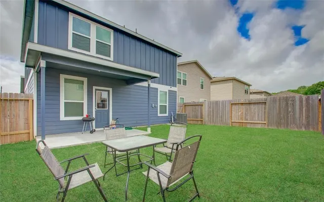 a view of an house with backyard and furniture