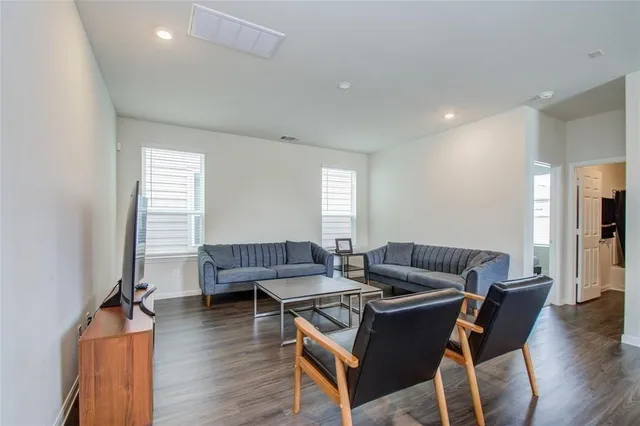 a living room with furniture and a wooden floor