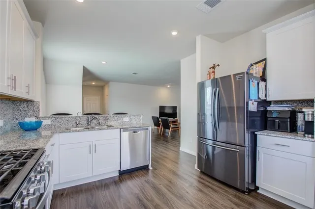 a kitchen with stainless steel appliances a refrigerator and a stove top oven