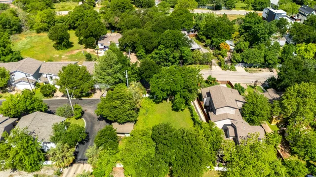 an aerial view of residential house with outdoor space and trees all around