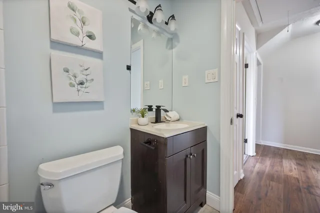 a bathroom with a granite countertop sink a toilet and a mirror