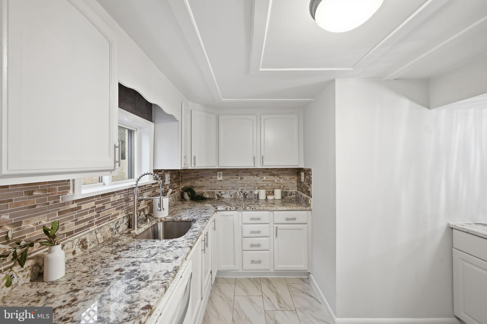 417 Meadow Road Baltimore, MD 21206 - Photo 33 of 47 a kitchen with a stove a sink and a refrigerator