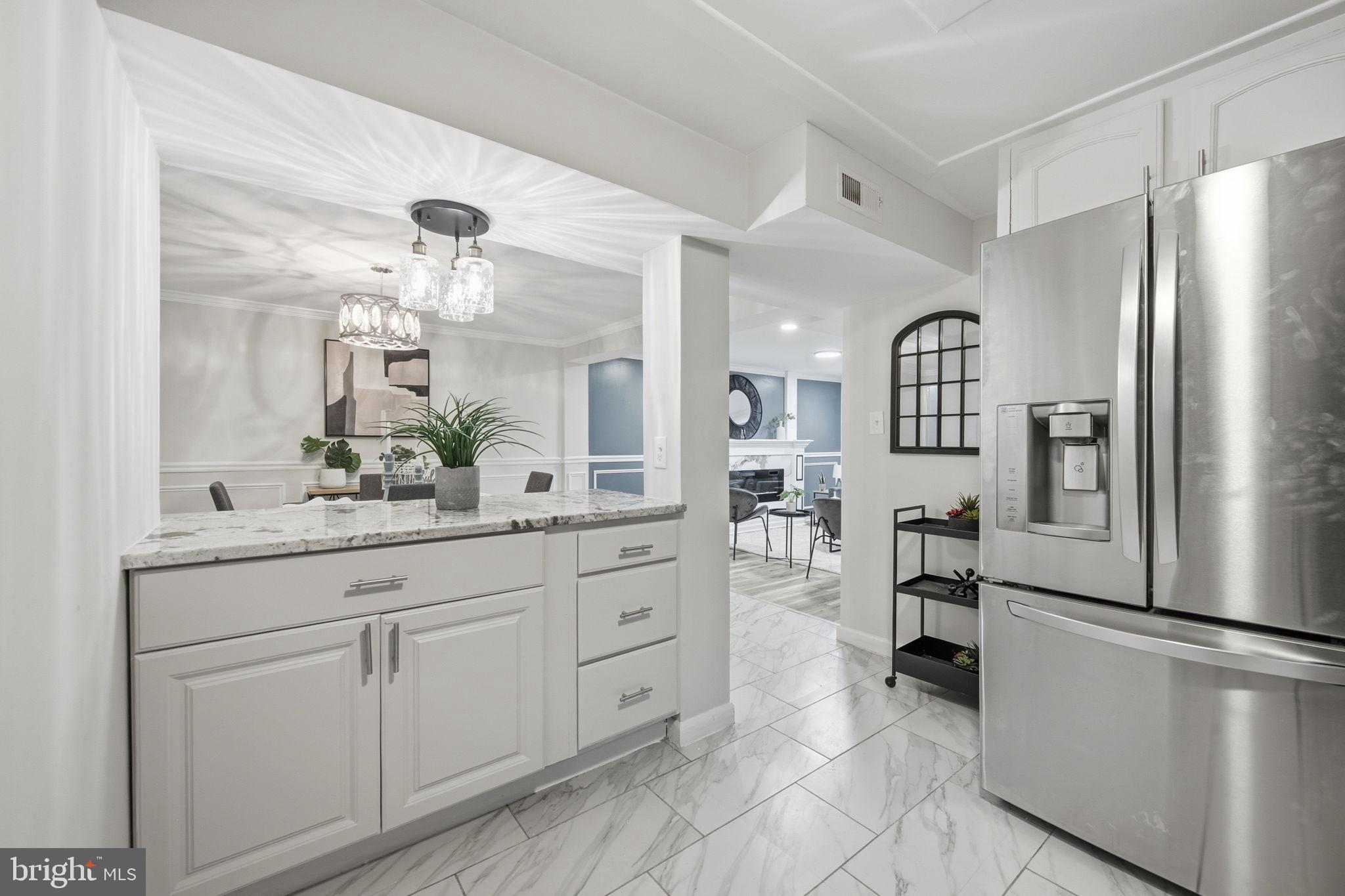 417 Meadow Road Baltimore, MD 21206 - Photo 35 of 47 a kitchen with white cabinets and stainless steel appliances