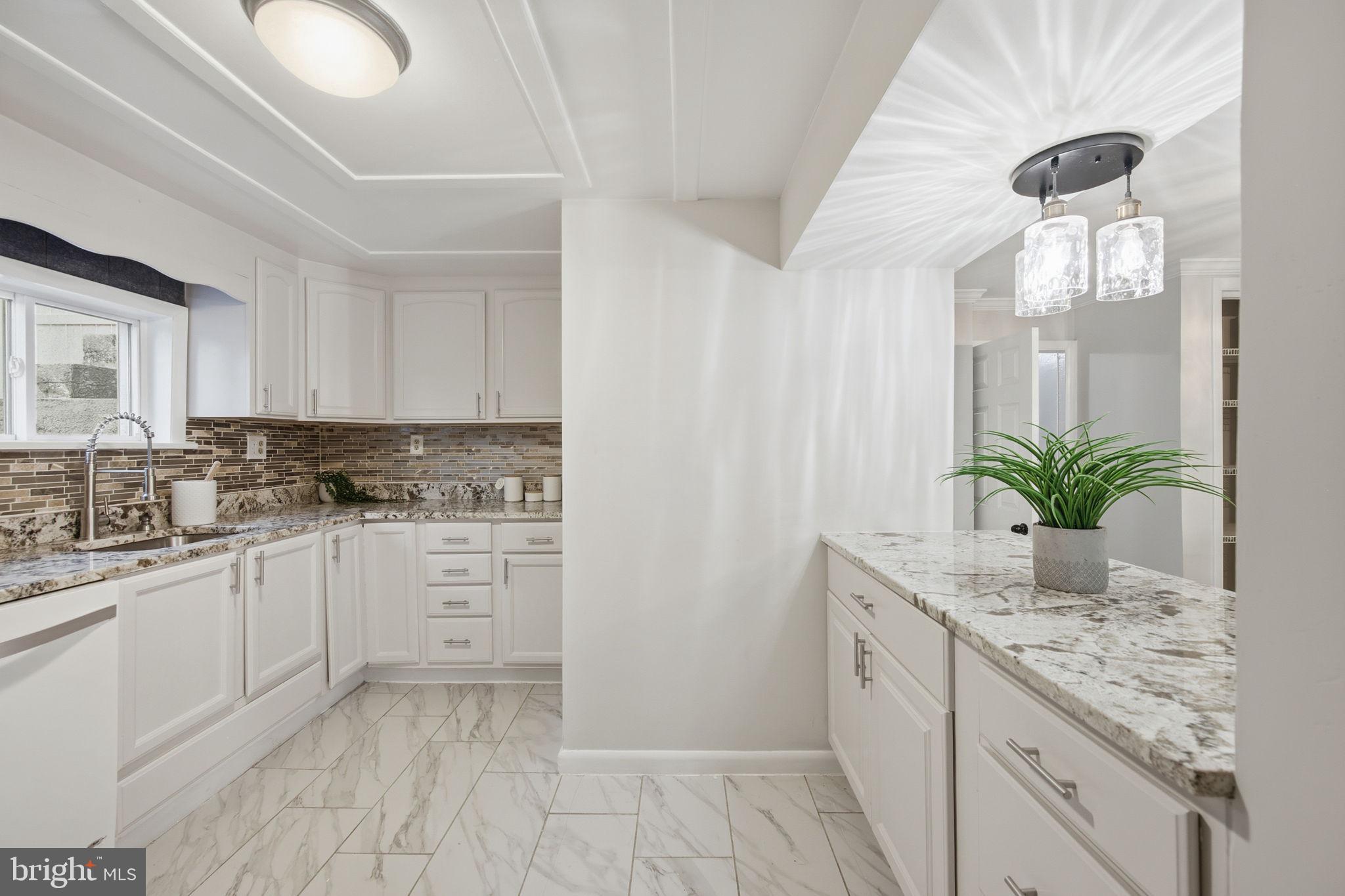 417 Meadow Road Baltimore, MD 21206 - Photo 38 of 47 a kitchen with granite countertop white cabinets and white appliances