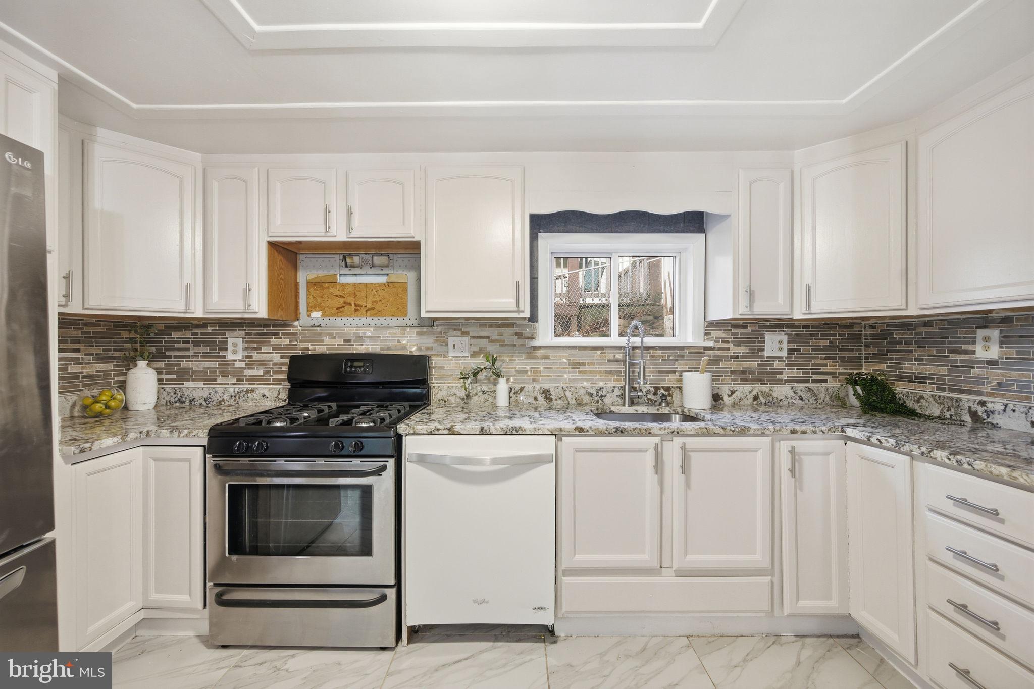 417 Meadow Road Baltimore, MD 21206 - Photo 39 of 47 a kitchen with granite countertop a stove sink and cabinets