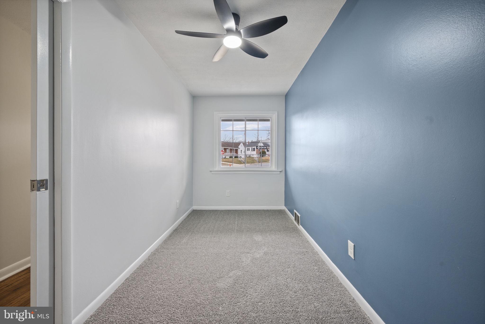 417 Meadow Road Baltimore, MD 21206 - Photo 10 of 47 an empty room with windows and ceiling fan