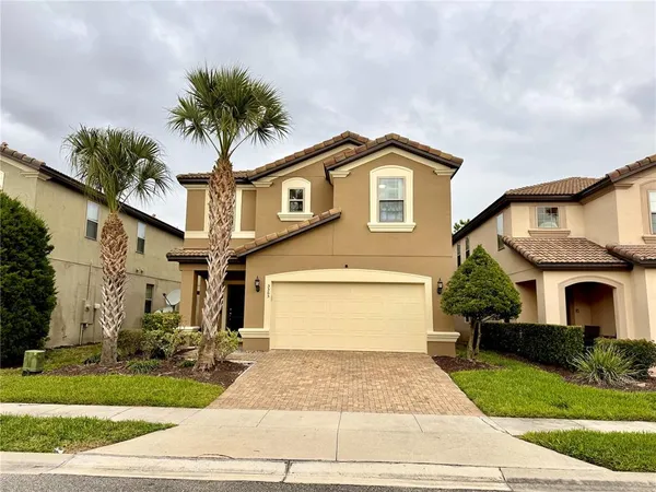 a front view of a house with a garden and palm trees
