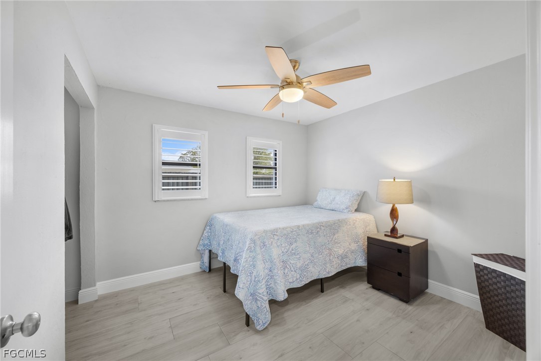 12991 Iona Road Fort Myers, FL 33908 - Photo 28 of 43 a bedroom with a bed and a chandelier
